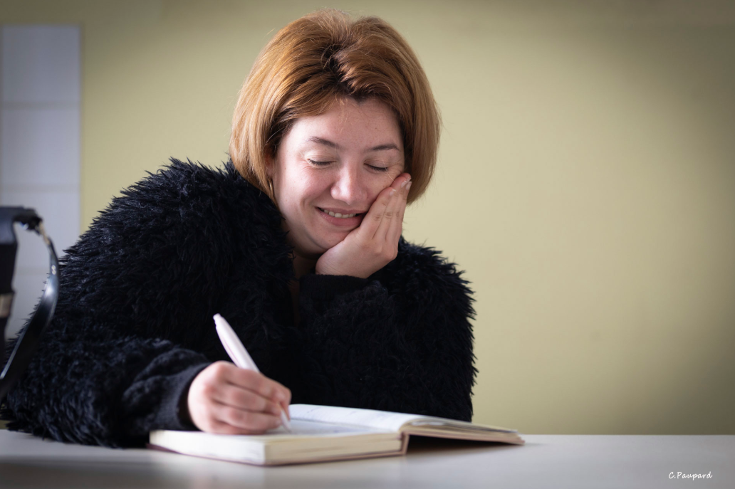 Personnage féminin écrivant sur un carnet